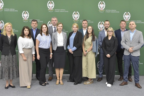  Zdjęcie grupowe uczestników zajęć na tle logo WSSG