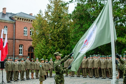 Funkcjonariusz prezentujący flagę WSSG