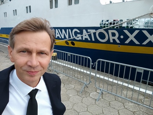 Wykładowca WSSG Krzysztof Szyca na tle jednostki pływającej Wykładowca WSSG Krzysztof Szyca na tle jednostki pływającej