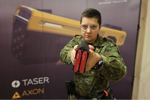Funkcjonariuszka WSSG trzyma w dłoniach paralizator Funkcjonariuszka WSSG trzyma w dłoniach paralizator