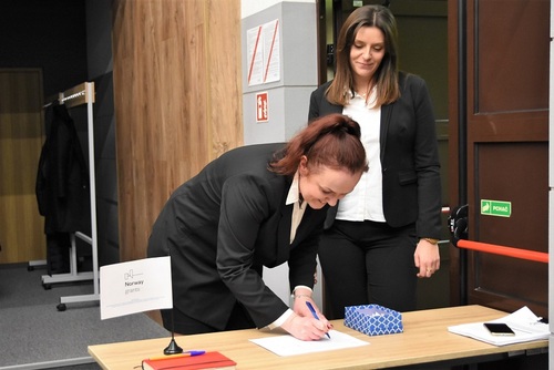 Przy wejściu do auli uczestniczki podpisują listę obecności, następnie będą losowały numer miejsca