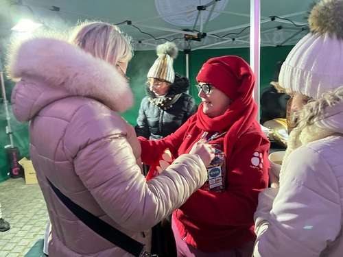 Wolontariuszka WOŚP przykleja naklejkę pracownicy Wolontariuszka WOŚP przykleja naklejkę pracownicy