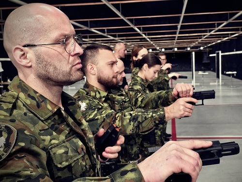 Uczestnicy szkolenia trzymają w dłoniach broń Uczestnicy szkolenia trzymają w dłoniach broń