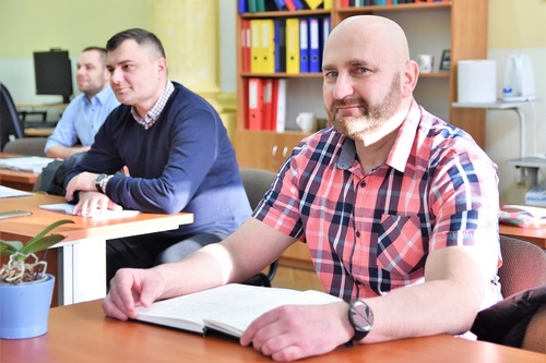 Uczestnik kursu z notatnikiem leżącym na biurku Uczestnik kursu z notatnikiem leżącym na biurku