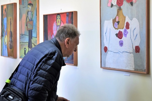 Zwiedzający wystawę przygląda się obrazowi Zwiedzający wystawę przygląda się obrazowi