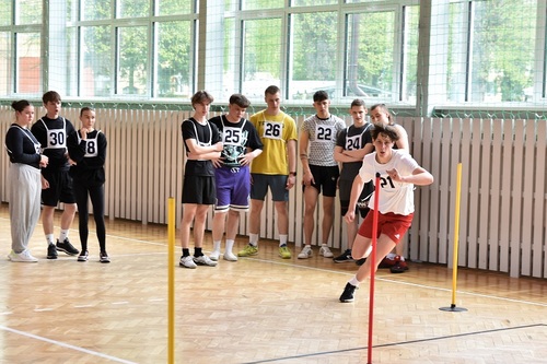 Grupa uczestników przyglądająca się uczestnikowi konkurencji sportowej Grupa uczestników przyglądająca się uczestnikowi konkurencji sportowej