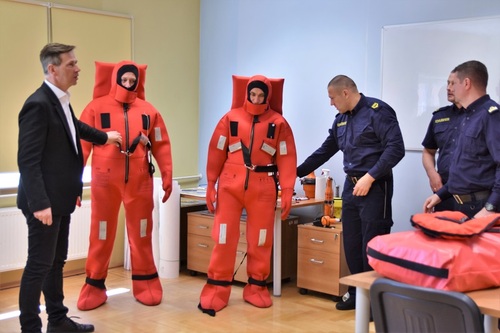 Wykładowca wraz z dwoma uczestnikami kursu ubranych w kombinezony ratunkowe Wykładowca wraz z dwoma uczestnikami kursu ubranych w kombinezony ratunkowe
