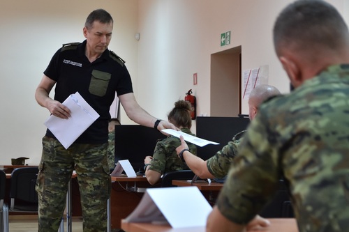 Płk SG Dariusz Jarmuziewicz rozdaje słuchaczom arkusze z egzaminem pisemnym Płk SG Dariusz Jarmuziewicz rozdaje słuchaczom arkusze z egzaminem pisemnym