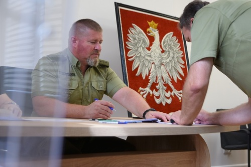 Członek komisji wyborczej na tle godła państwowego Członek komisji wyborczej na tle godła państwowego