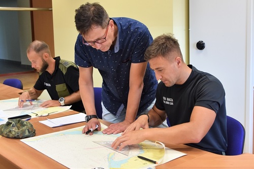 Funkcjonariusze MOSG z wykładowcą podczas ćwiczeń z mapą morską Funkcjonariusze MOSG z wykładowcą podczas ćwiczeń z mapą morską