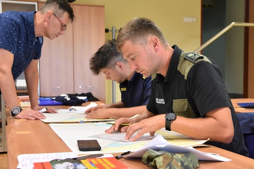 Funkcjonariusze MOSG z wykładowcą podczas ćwiczeń z mapą morską Funkcjonariusze MOSG z wykładowcą podczas ćwiczeń z mapą morską