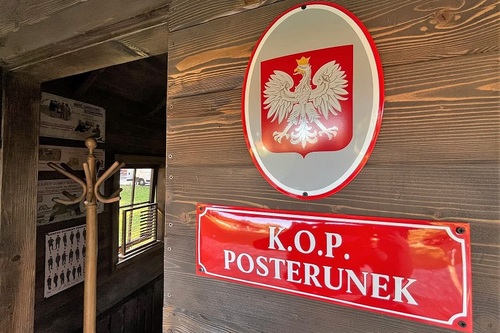 Godło państwowe Polski oraz metalowa tabliczka z napisem "K.O.P. POSTERUNEK. W tle widać część wyposażenia posterunku Godło państwowe Polski oraz metalowa tabliczka z napisem &quot;K.O.P. POSTERUNEK. W tle widać część wyposażena posterunku