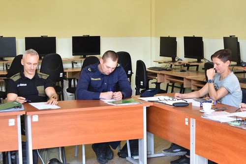 Funkcjonariusze SG wykonują zadania w ławkach, na drugim planie widać komputery Funkcjonariusze SG wykonują zadania w ławkach, na drugim planie widać komputery