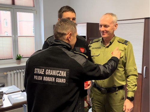 Funkcjonariusz SG przykleja Rektorowi-Komendantowi WSSG serduszko WOŚP Funkcjonariusz SG przykleja Rektorowi-Komendantowi WSSG serduszko WOŚP